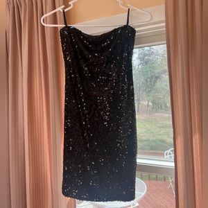 Black, short sequined dress. Open back with three horizontal spandex straps.